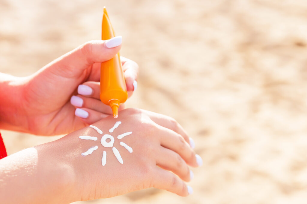 a person applying sun cream on a hand Sonnenschutz für die Haut – die besten Tipps für jeden Hauttyp